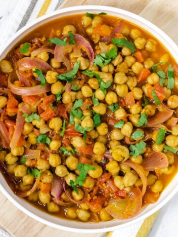 Punjabi chole with chickpeas in wide white bowl.