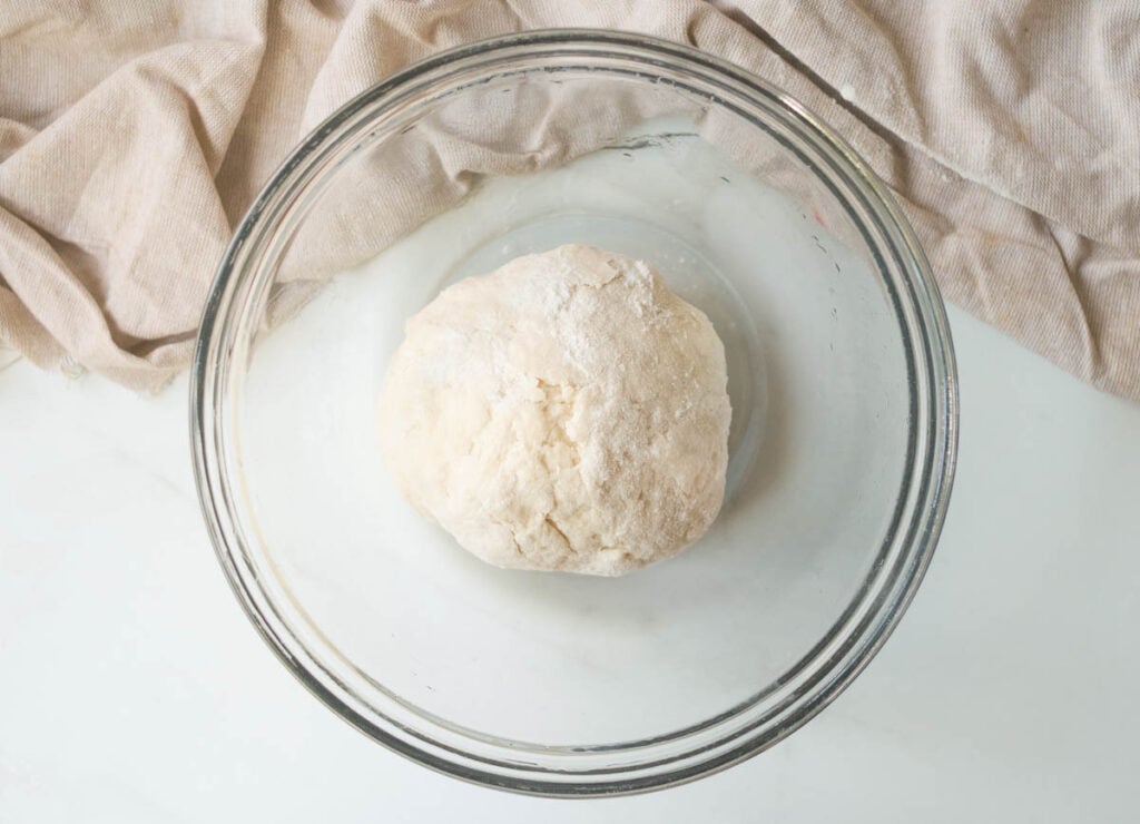 Ball of dough in glass bowl.