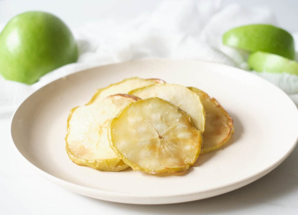 Apple chips on white plate.