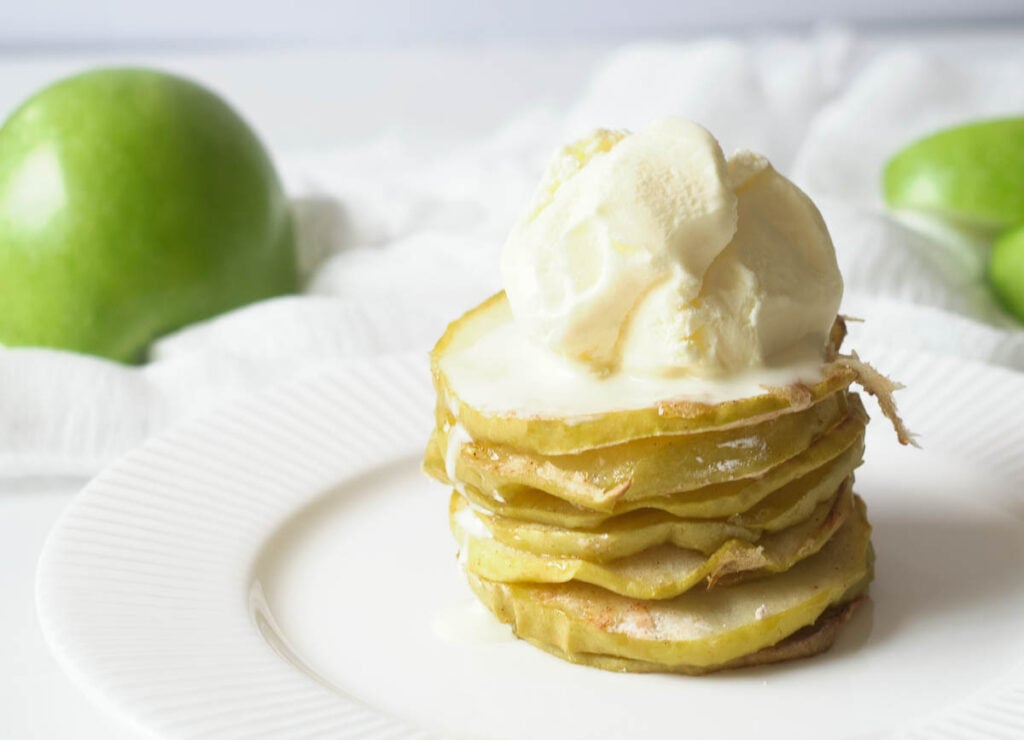 Stack of apple chips topped with vanilla ice cream. 