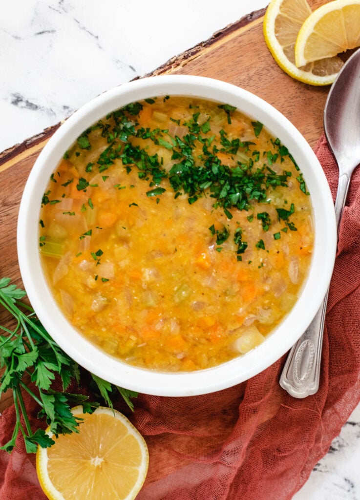 Lebanese lentil soup in white bowl topped with parsley.