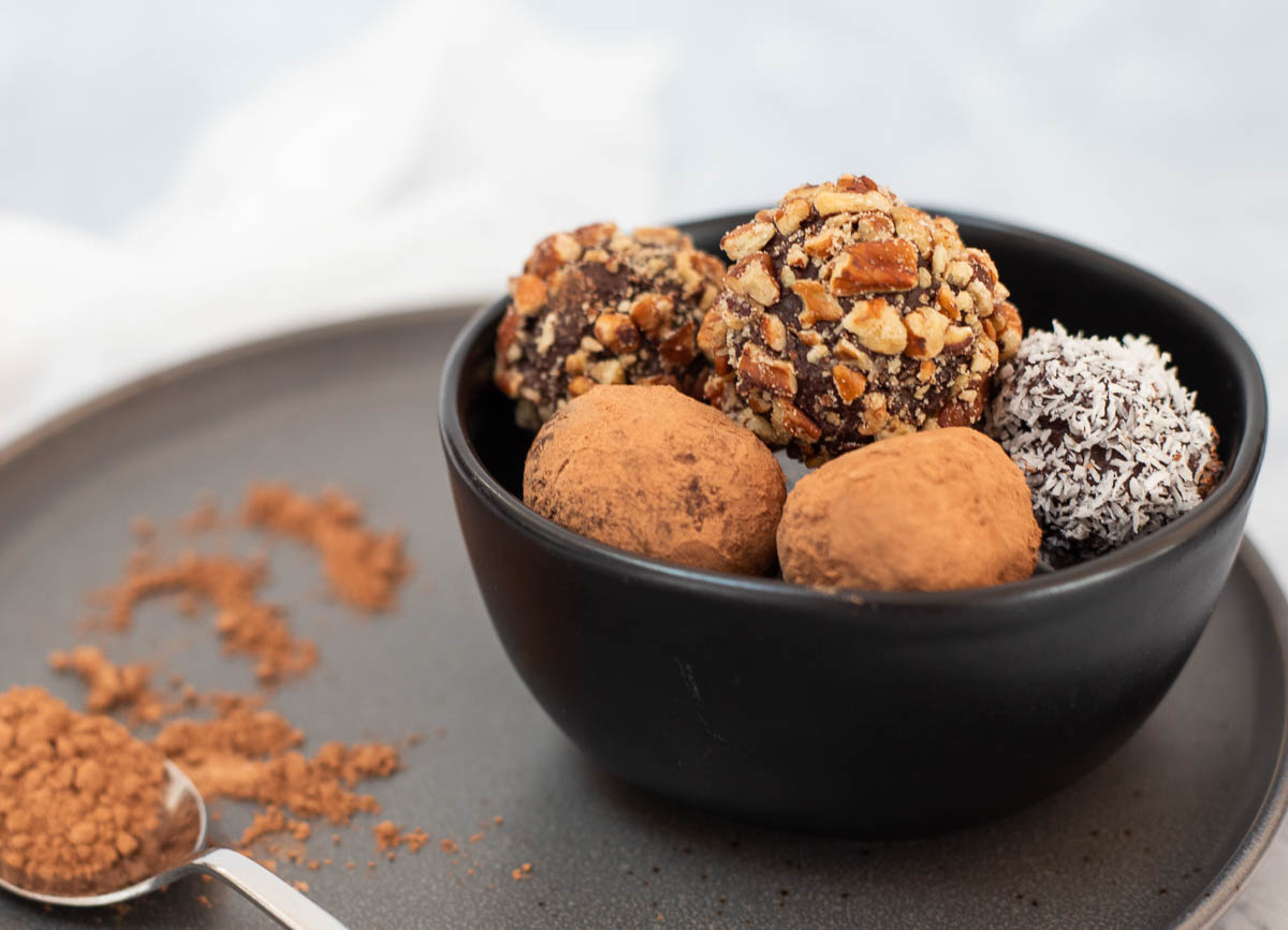 Chocolate vegan truffles in black bowl. 