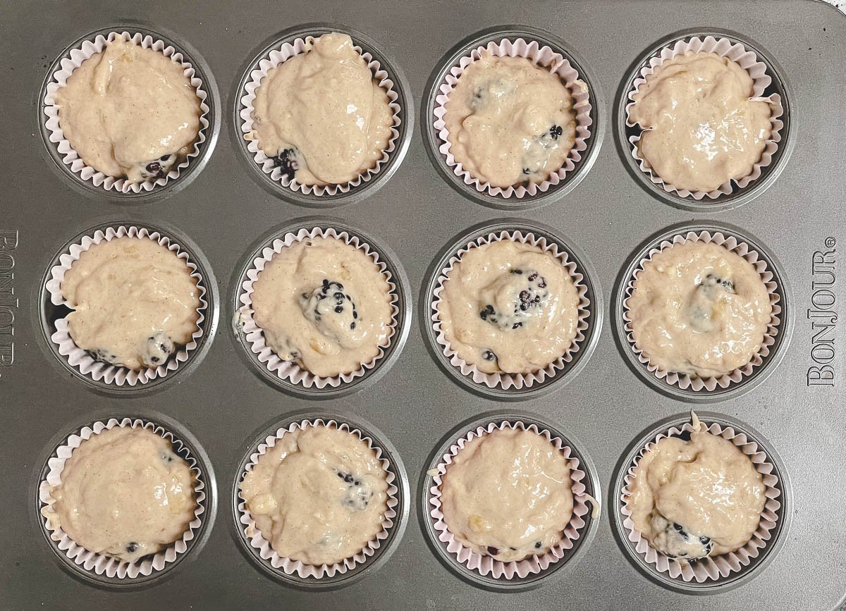 Blackberry muffin batter in muffin cups. 