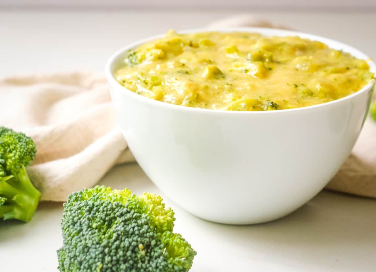 Large bowl of thick and creamy broccoli and cheddar soup.