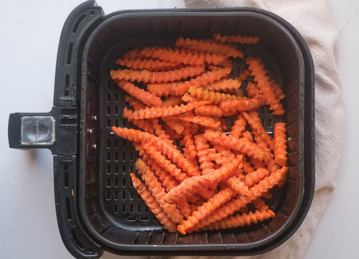 Sweet potato fries in air fryer basket. 