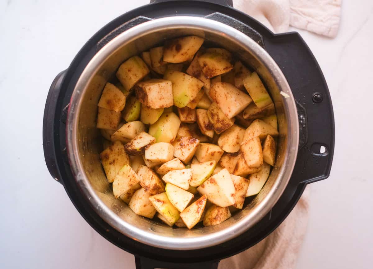 Diced apples coated in cinnamon in Instant Pot. 