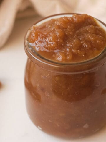 Instant pot apple butter in small glass jar.