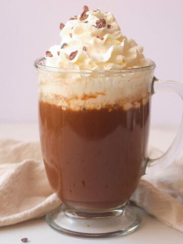 Mocha latte topped with whipped cream and chocolate shavings.