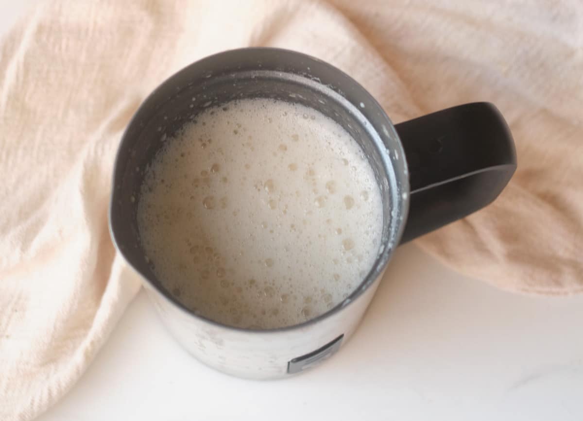 Frothed almond milk in an electric milk frother. 