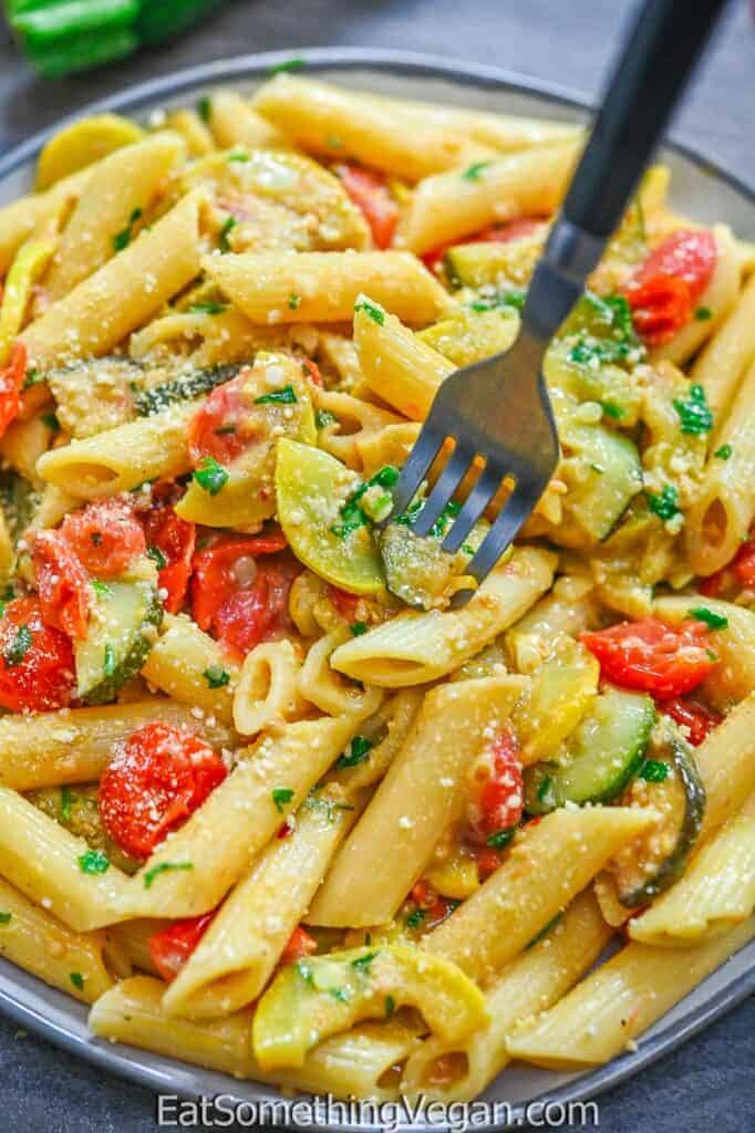 Creamy zucchini and yellow squash pasta with a fork.