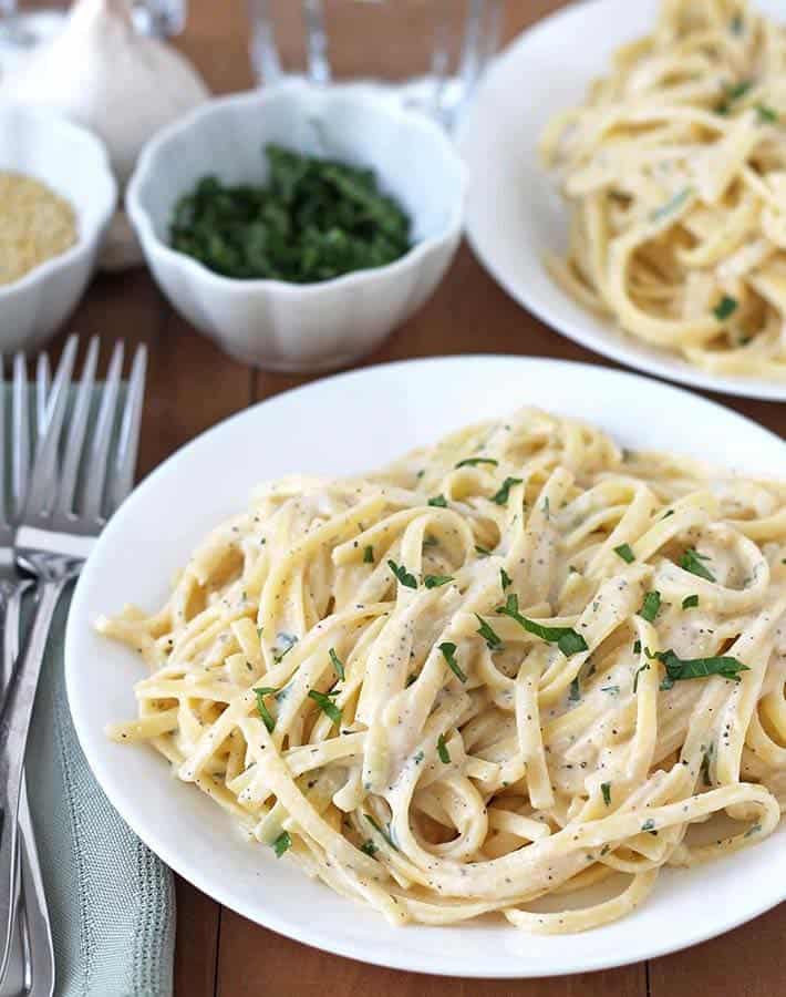 Creamy garlic pasta in white bowl. 