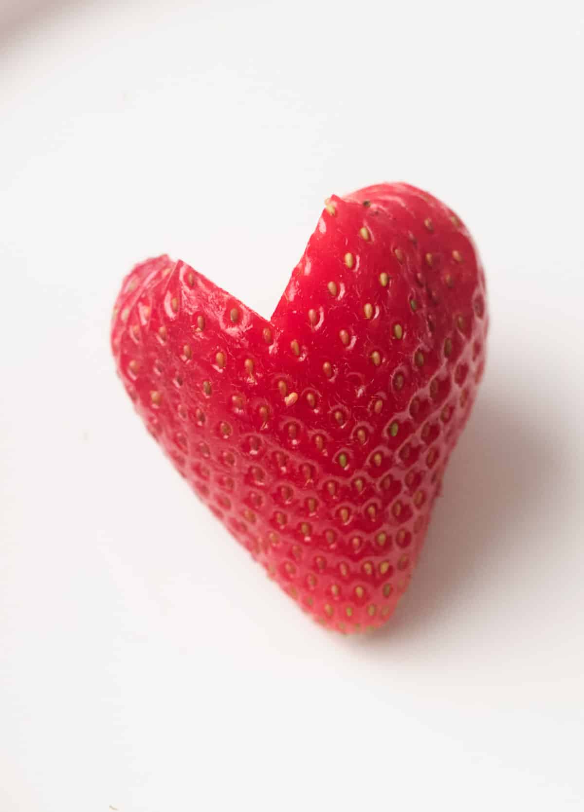 Single strawberry cut into a heart shape.