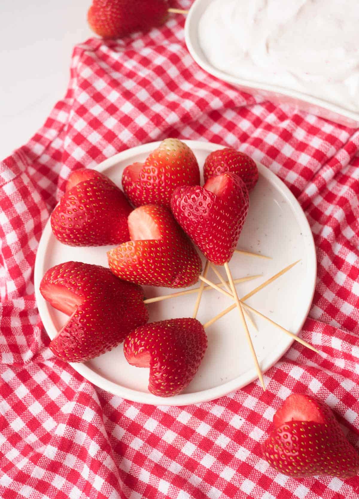 Strawberry hearts with toothpicks stuck in the bottom. 