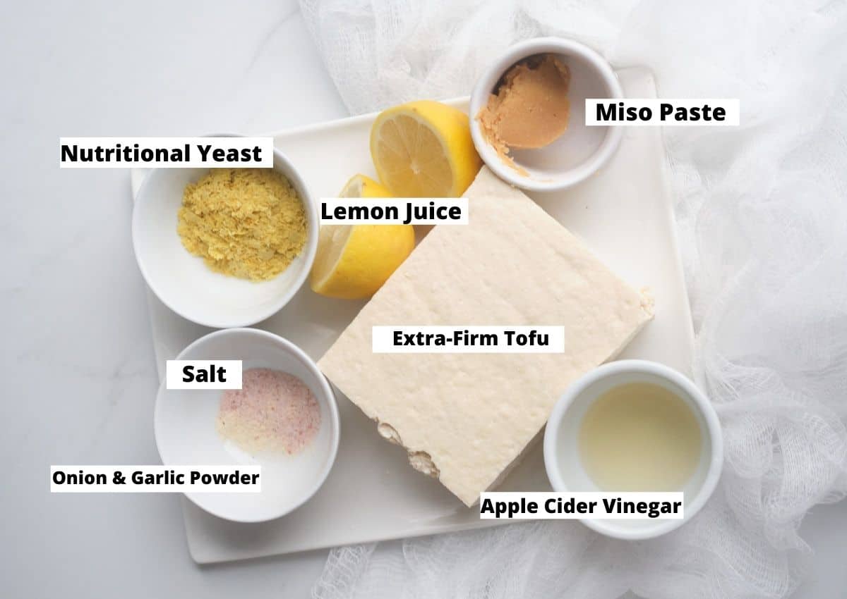 Vegan feta ingredients: nutritional yeast, lemons, miso paste, tofu, apple cider vinegar, salt, and onion and garlic powder.