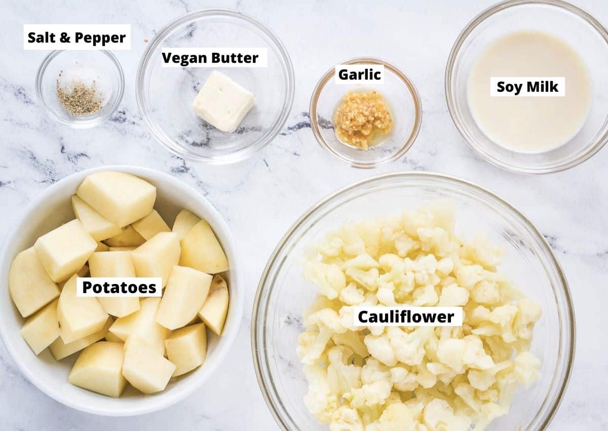 Healthy mashed potato ingredients: cubed russet potato, cauliflower florets, soy milk, garlic, vegan butter, salt, and pepper.