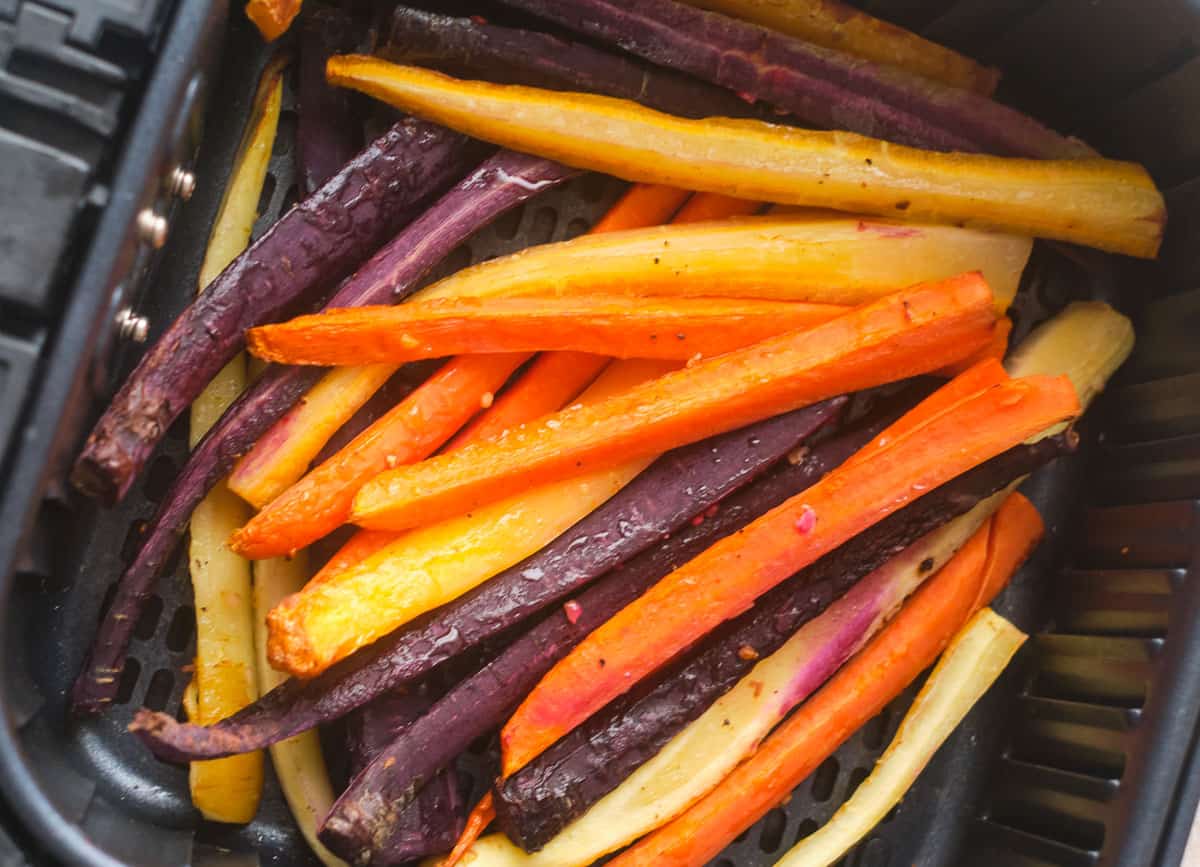 Rainbow carrots in air fryer basket. 