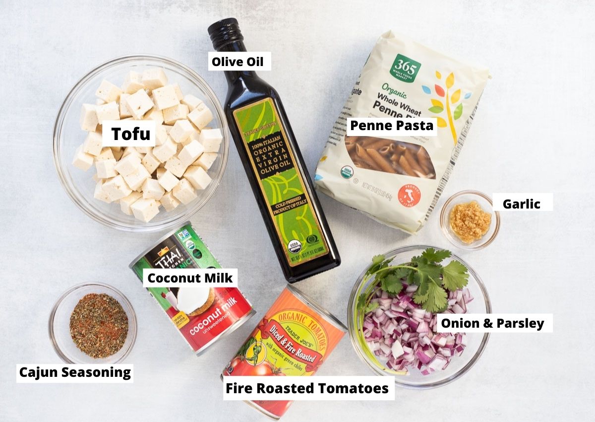 Ingredients for vegan cajun past: tofu, olive oil penne pasta, garlic, onions, parsley, fire roasted tomatoes, coconut milk, cajun seasoning. 
