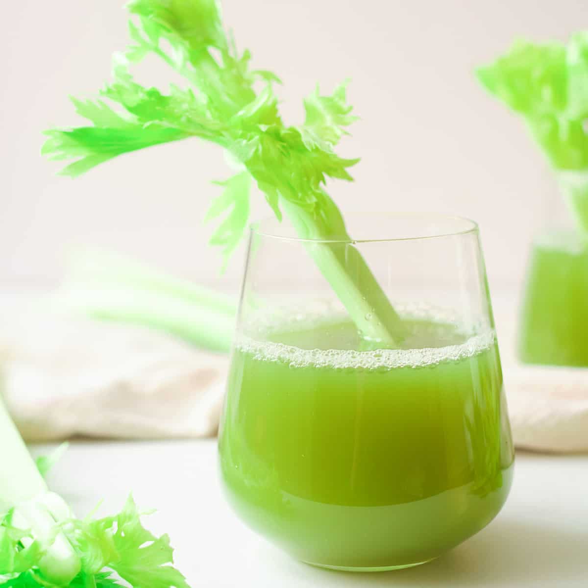 Glass of celery juice with stalk. 