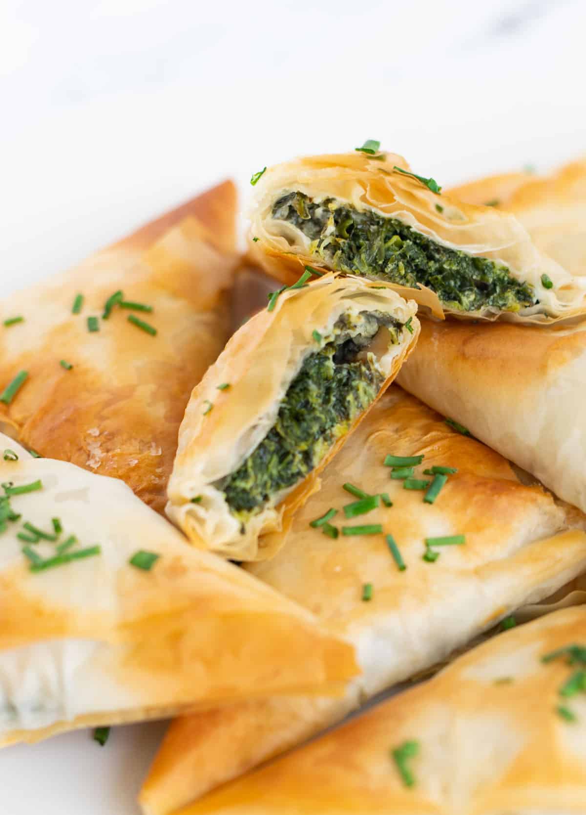 Close up of vegan spanakopita topped with fresh chives. 