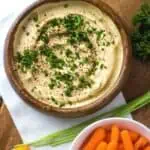 Bowl of hummus with a side of carrots.