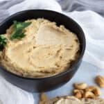 Cashew ricotta in black bowl with parsley.