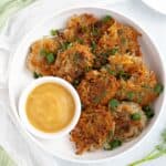 Vegan potato pancakes in shallow white bowl, served with a side of applesauce.