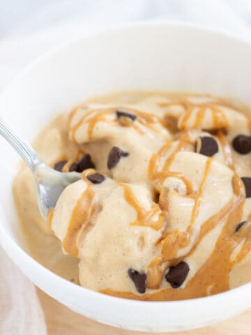 Protein fluff in white bowl topped with peanut butter and chocolate chips.
