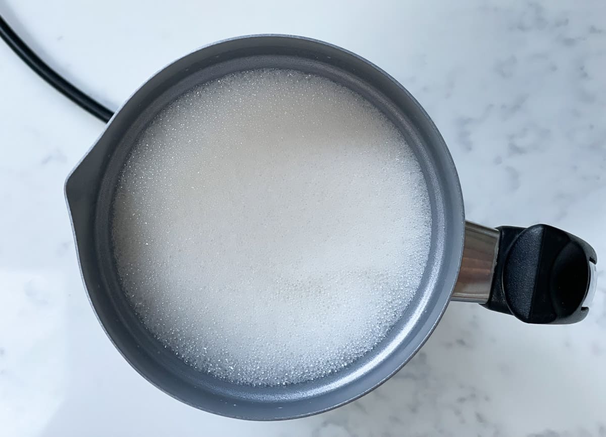 Frothed soy milk in silver milk frothing pitcher. 
