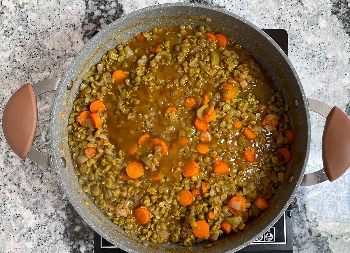 Split pea vegan soup simmering in pot. 