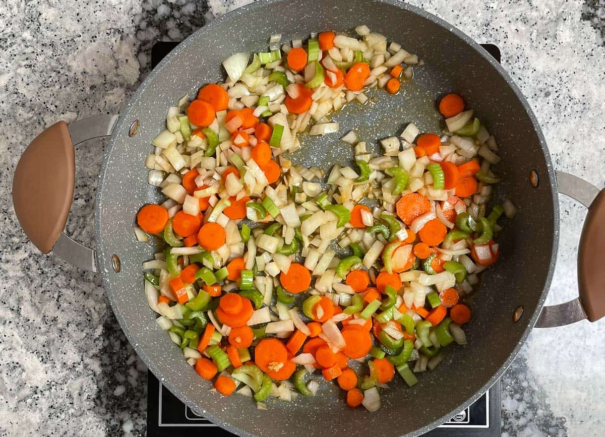 Diced onion, carrots, and celery in pot. 