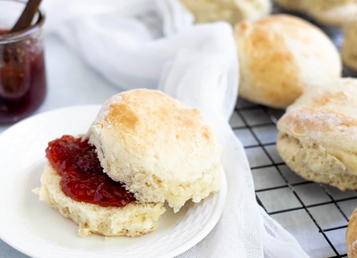 Baked scone on plate with jam inside. 