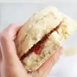 hand holding vegan scone with jam.