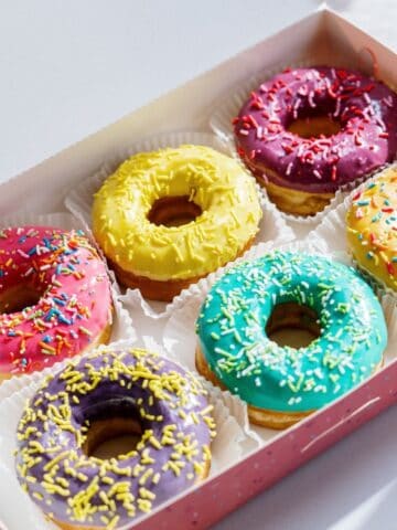 Box of colorful glazed donuts.