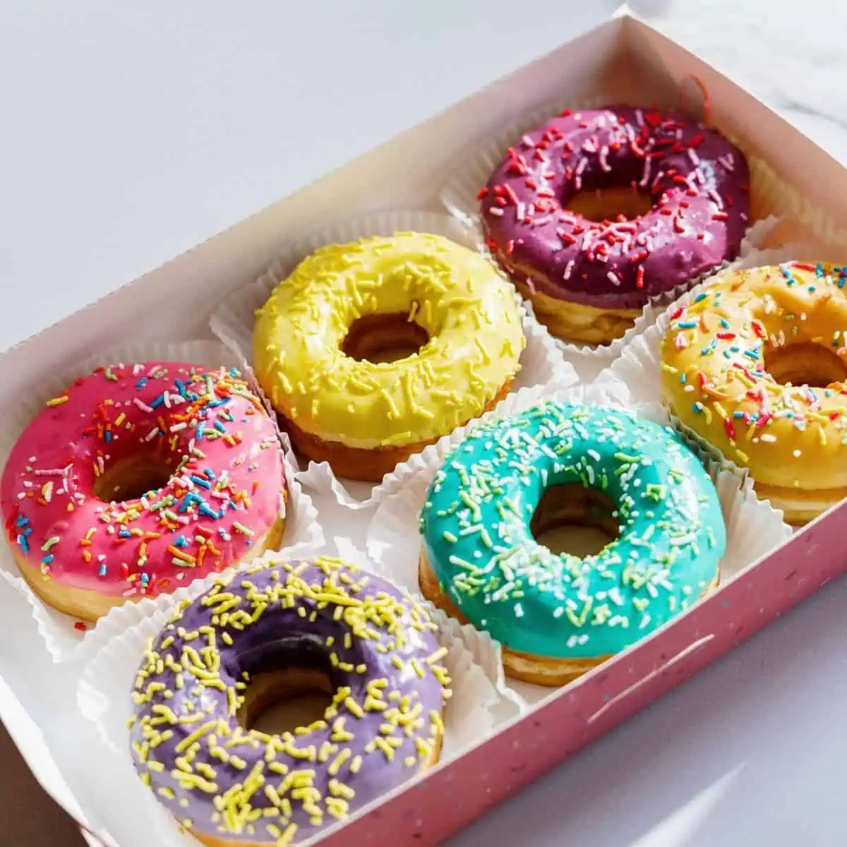 Box of colorful glazed donuts. 