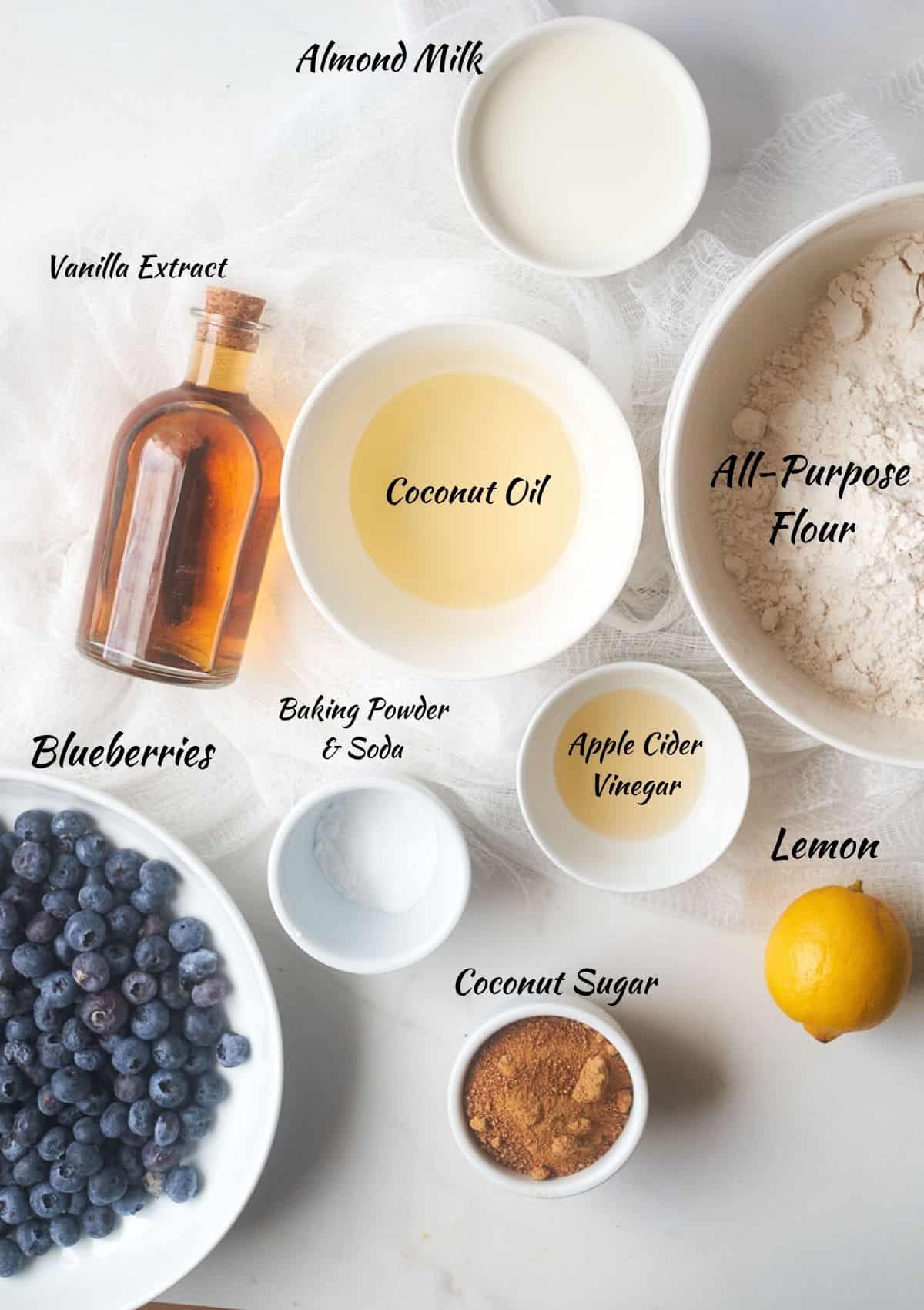 Blueberry Cake Ingredients: Almond milk, all-purpose flour, coconut oil, vanilla extract, blueberries, baking powder, baking soda, apple cider vinegar, lemon, coconut sugar.