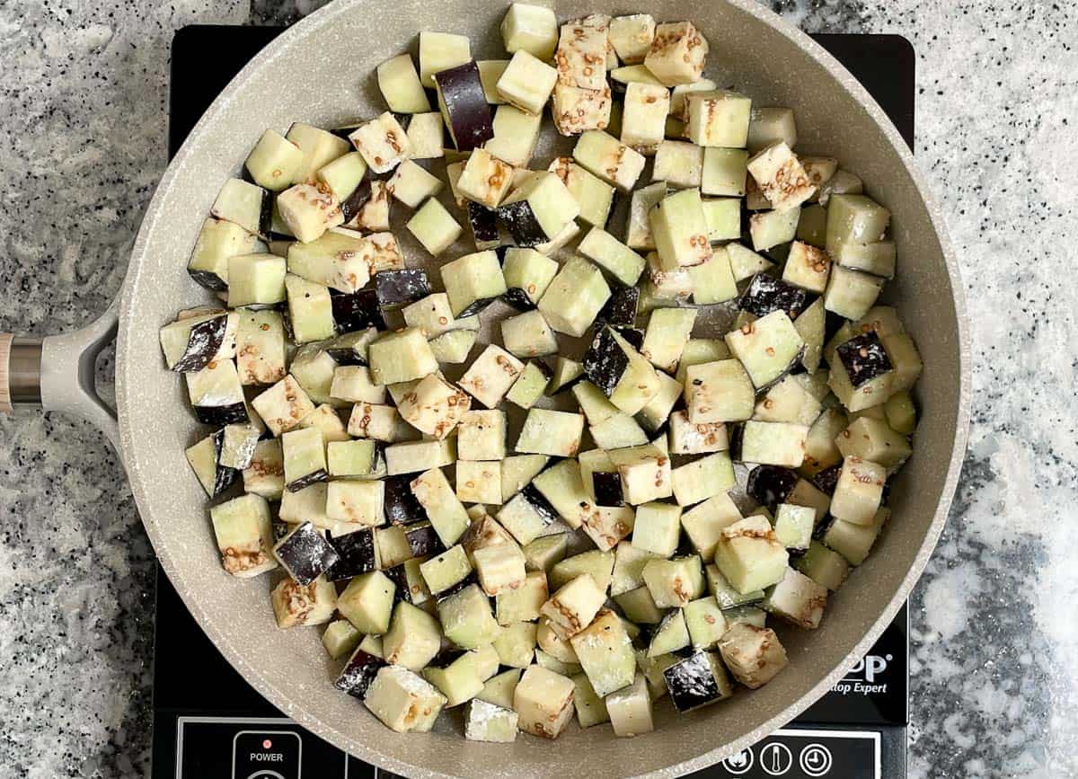 Diced eggplant in saute pan.