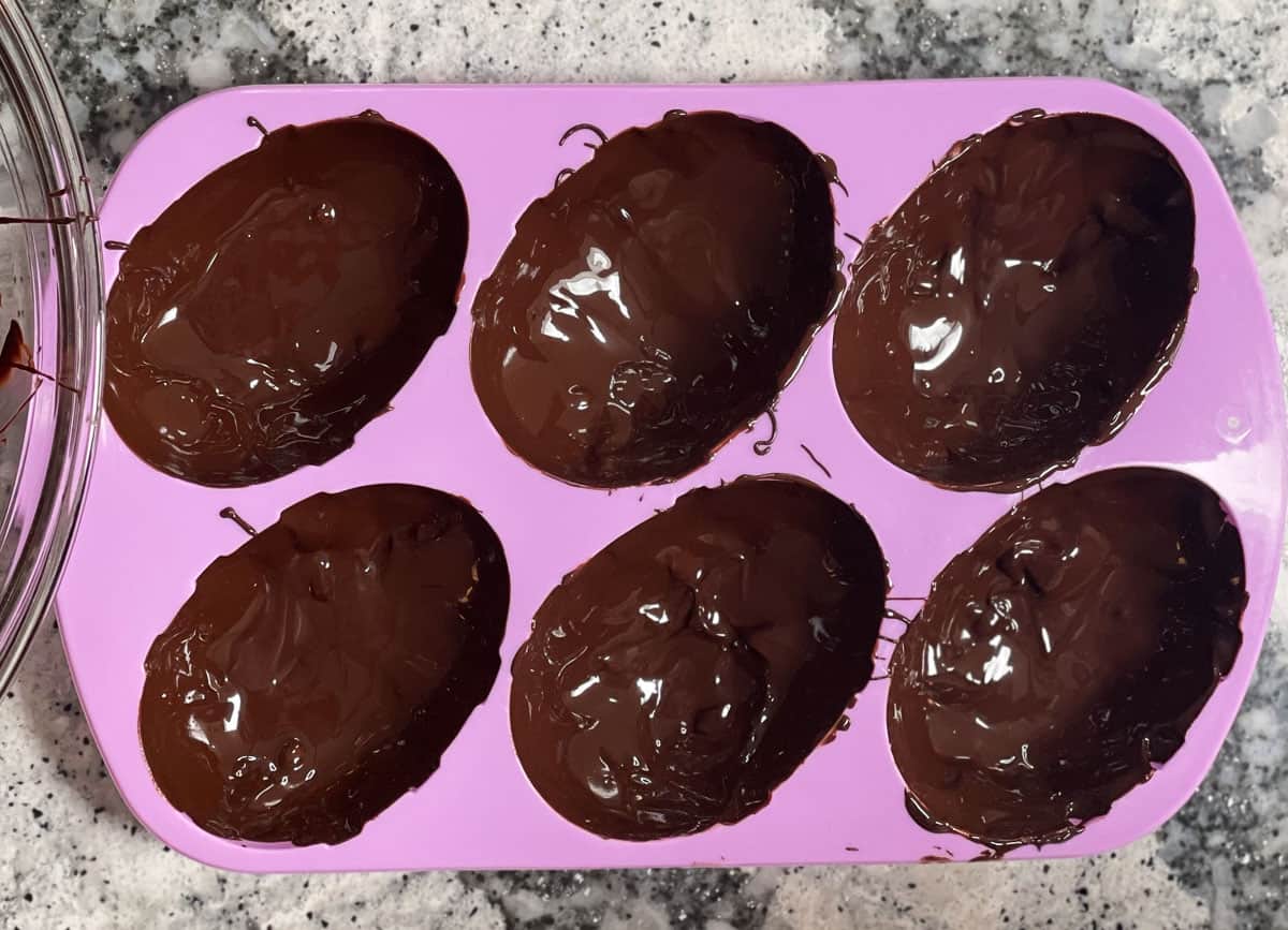 Egg mold filled with melted chocolate.