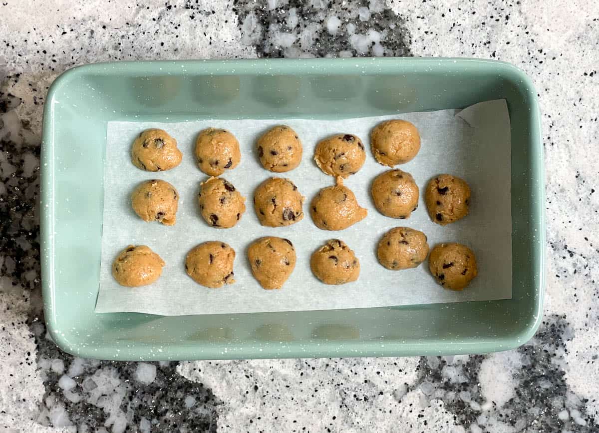 Small cookie dough bites in 9-inch loaf pan lined with parchment paper.