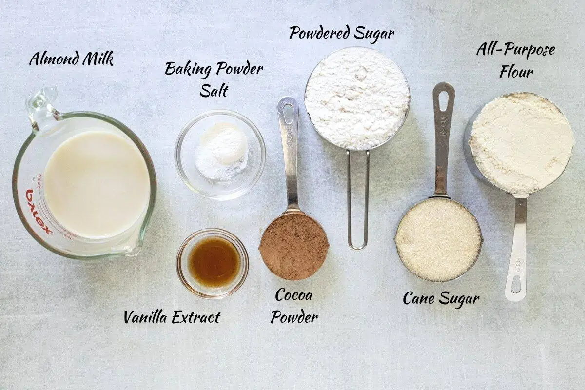 Eggless Donut Recipe Ingredients: almond milk, baking powder, salt, vanilla extract, cocoa powder, powdered sugar, cane sugar, all-purpose flour. 