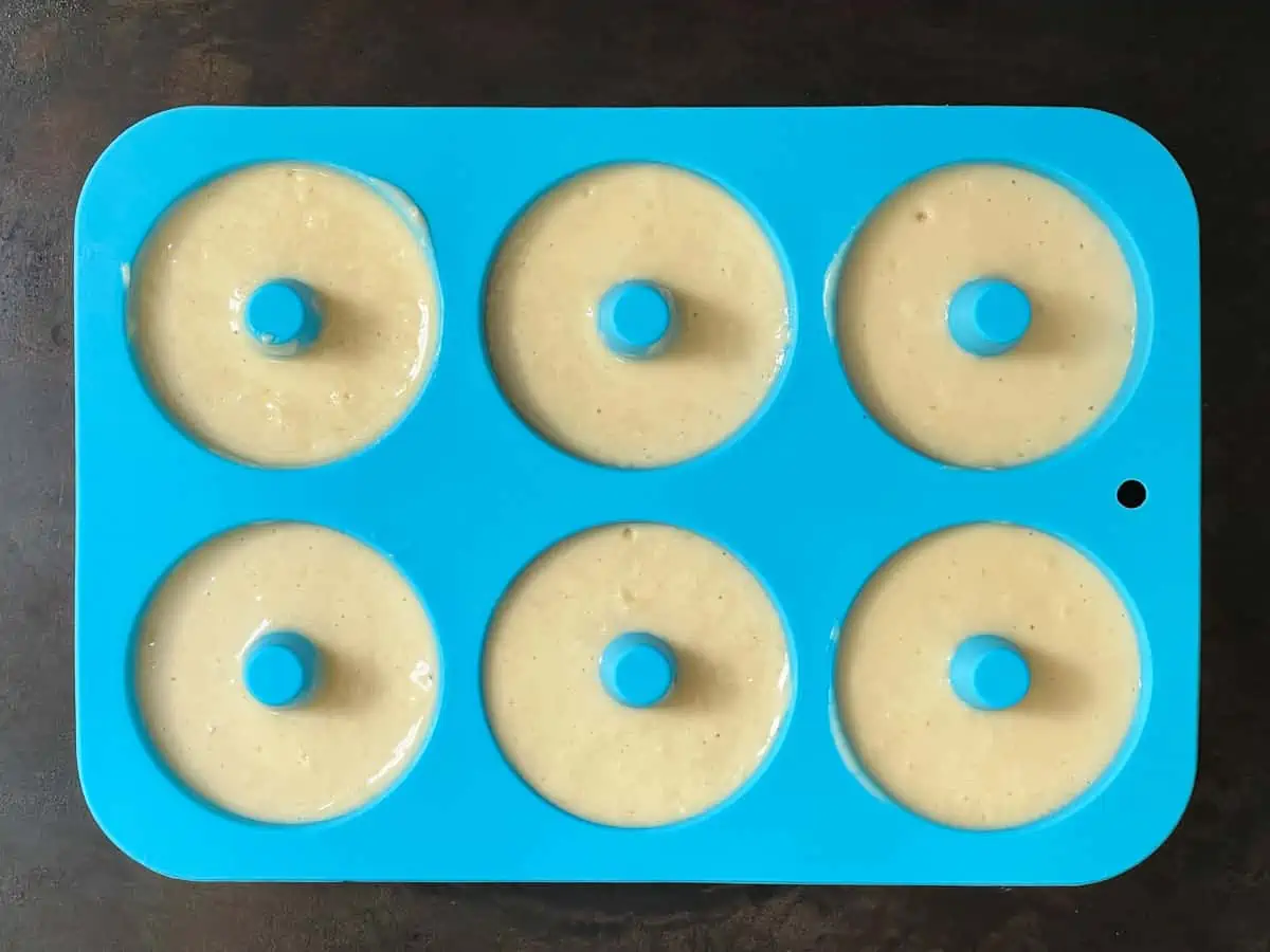 Batter added to silicone donut mold. 