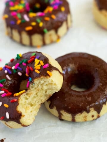 Eggless donuts with vanilla cake and chocolate icing and sprinkles.