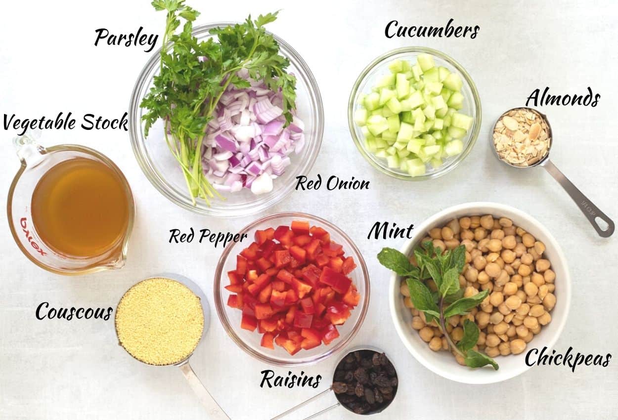 Ingredients for Couscous Moroccan Salad: diced onions, parsley, diced cucumber, almonds, chickpeas, mint, raisins, diced red pepper, couscous, vegetable stock. 