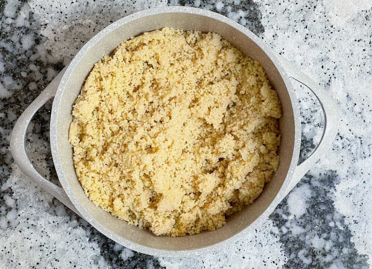 Cooked couscous in large pot.