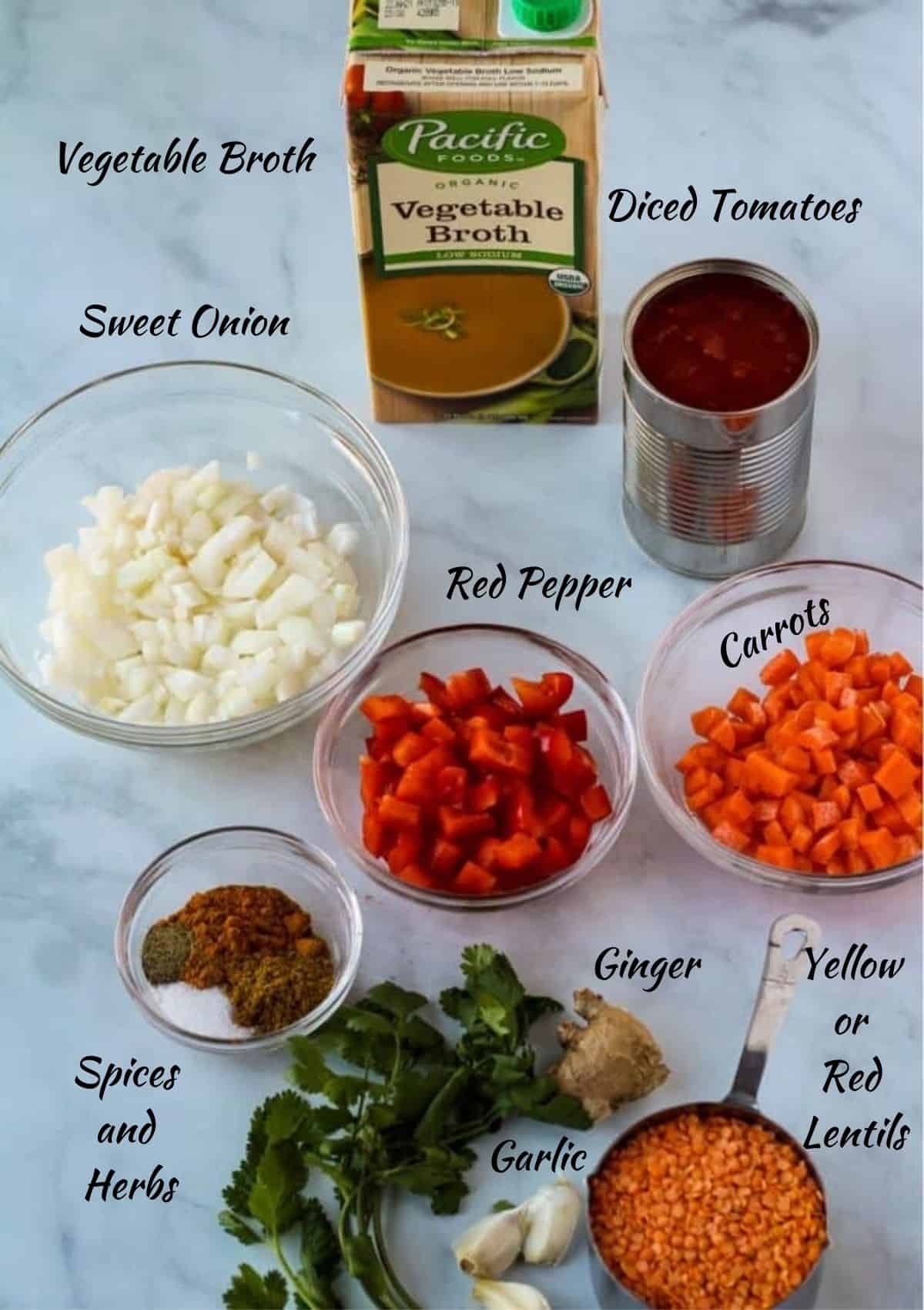 All the ingredients needed to make vegan curried lentils. Vegetable broth, diced tomatoes, diced onion, red pepper, carrots, ginger, spices, red lentils. 