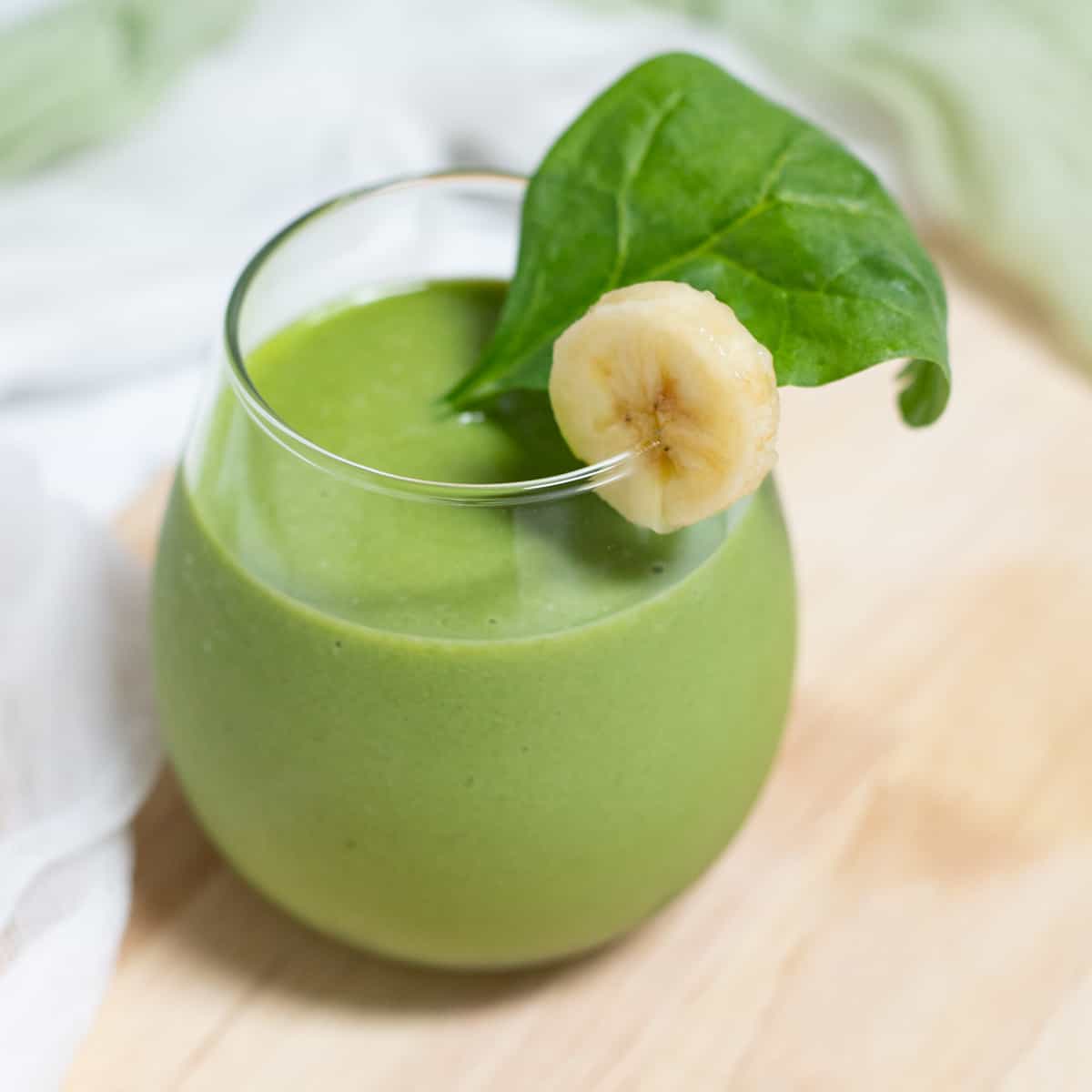 Banana spinach smoothie in glass.