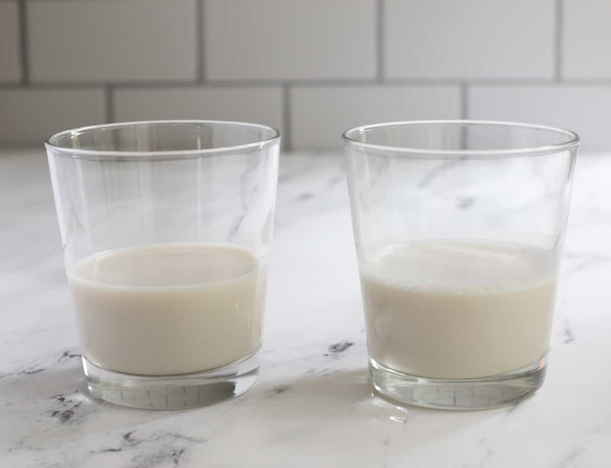 Two glasses filled with almond milk. One glass is fresh almond milk and the other is defrosted and blended almond milk.
