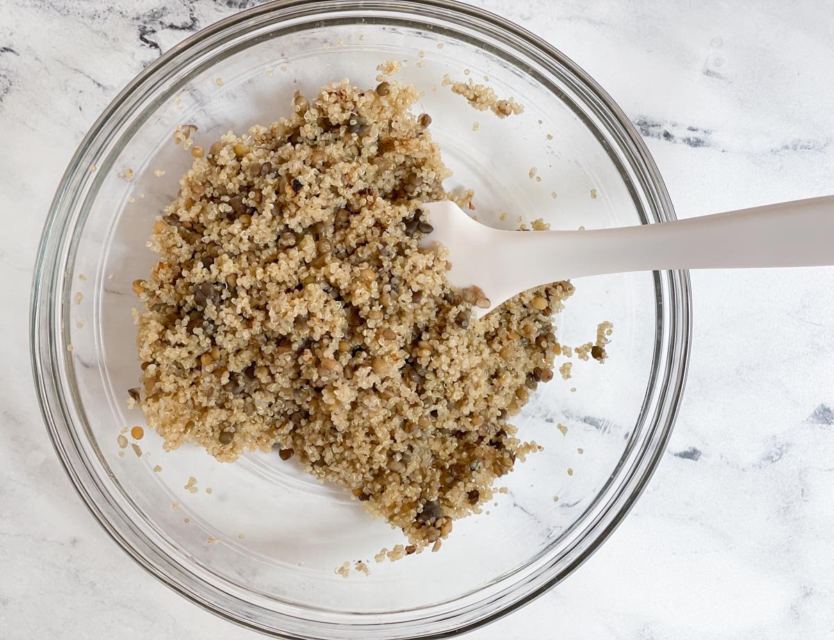 Quinoa and lentils combined in large glass bowl. 