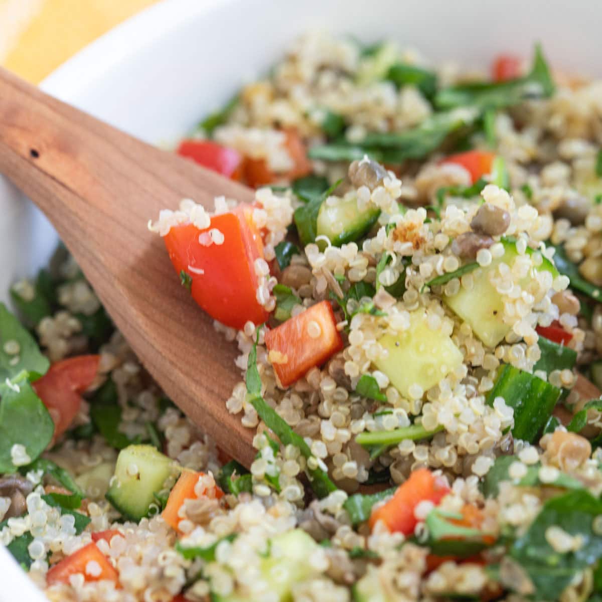 Wooden spoon lifting serving of copycat Costco quinoa salad.