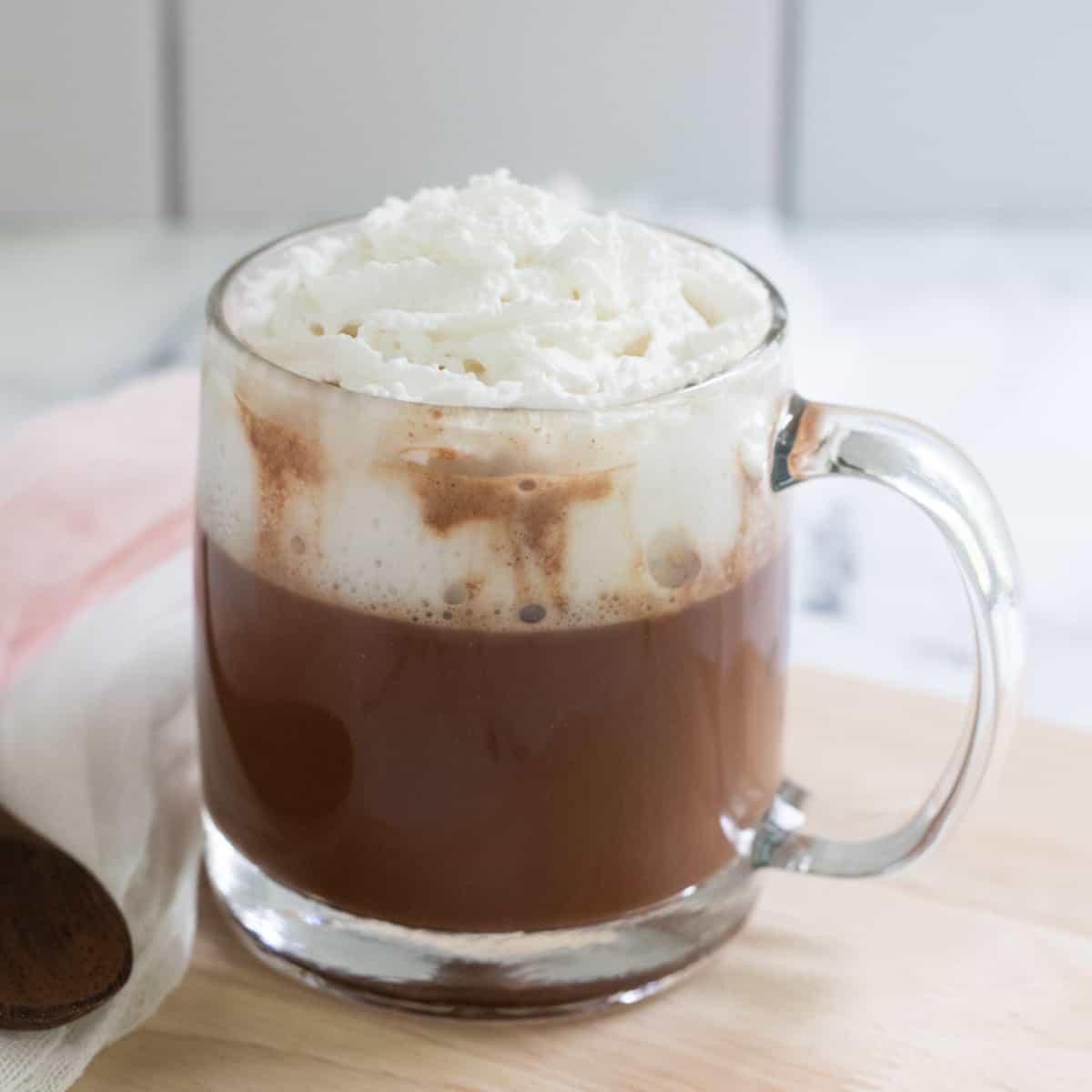 Cup of oat milk hot chocolate topped with coconut whipped cream. 