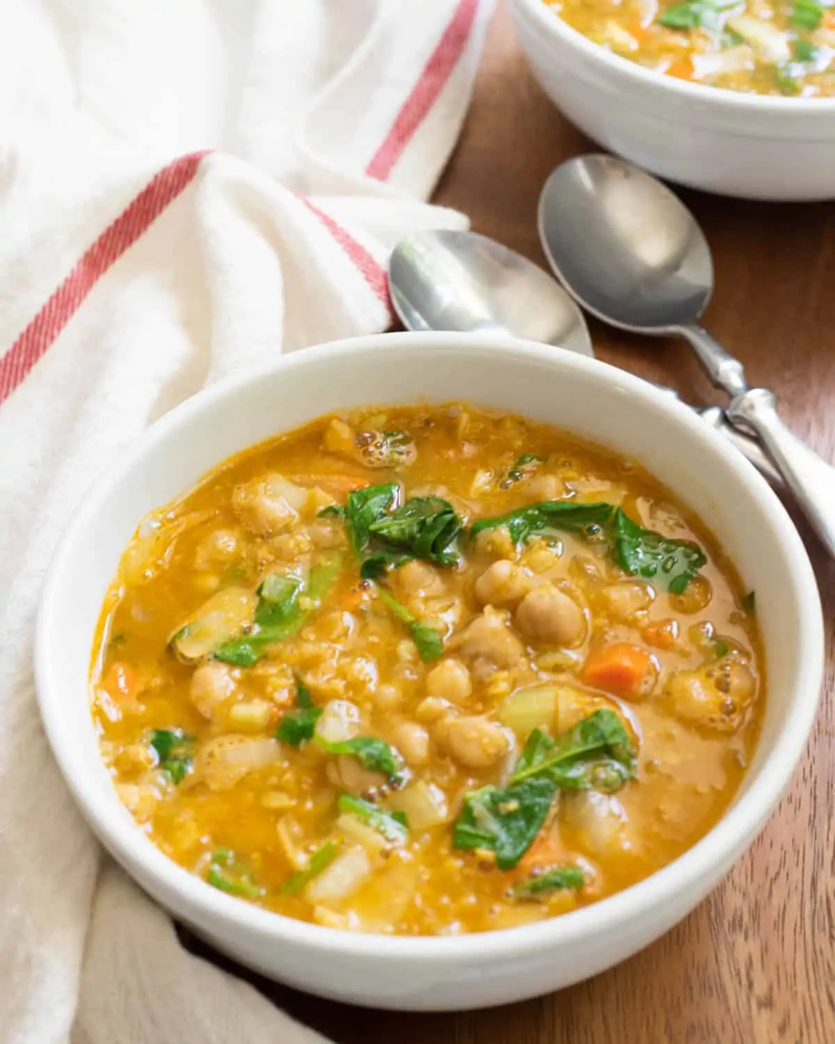 Greek Chickpea soup and spinach soup in white bowl. 
